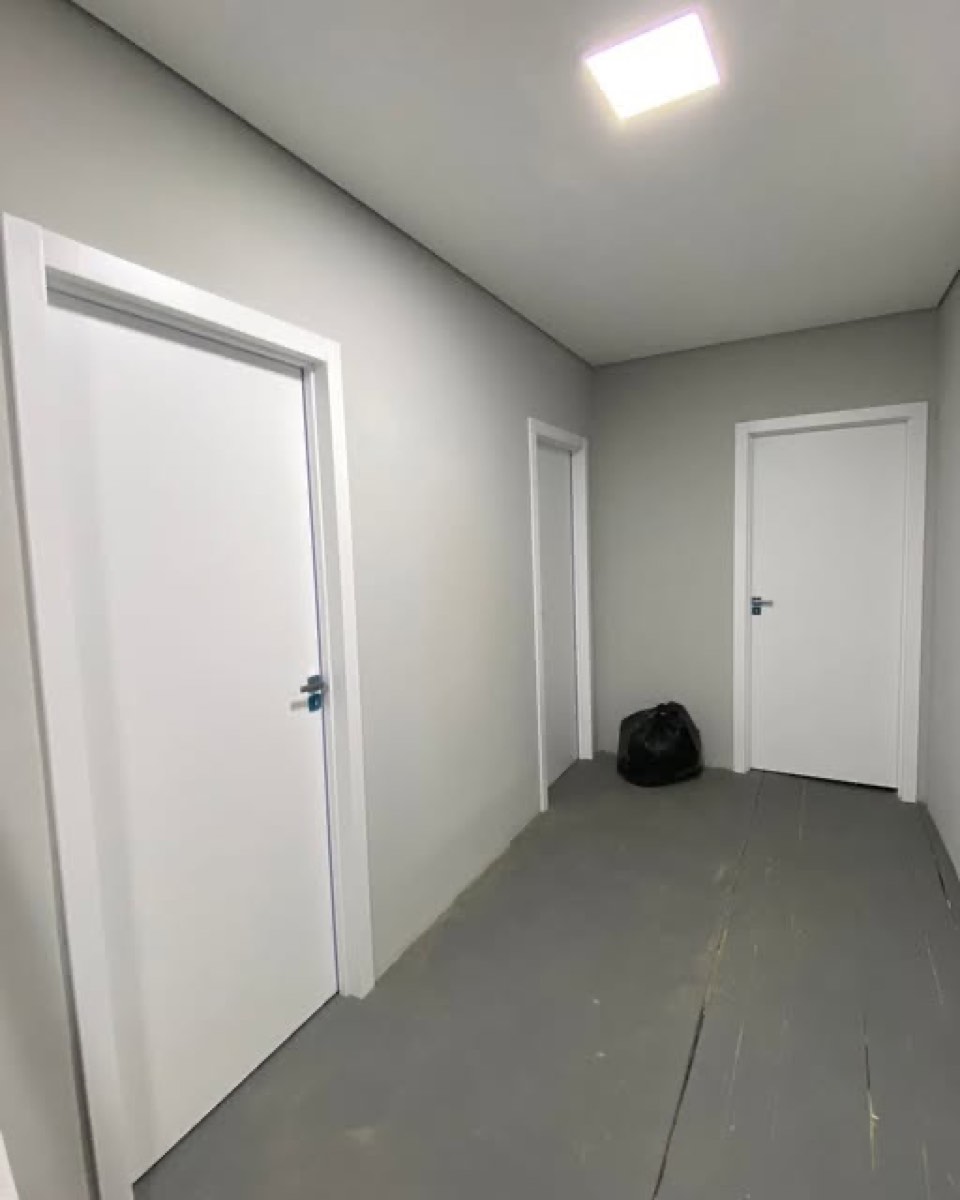 Corredor com três portas brancas instaladas em obra finalizada